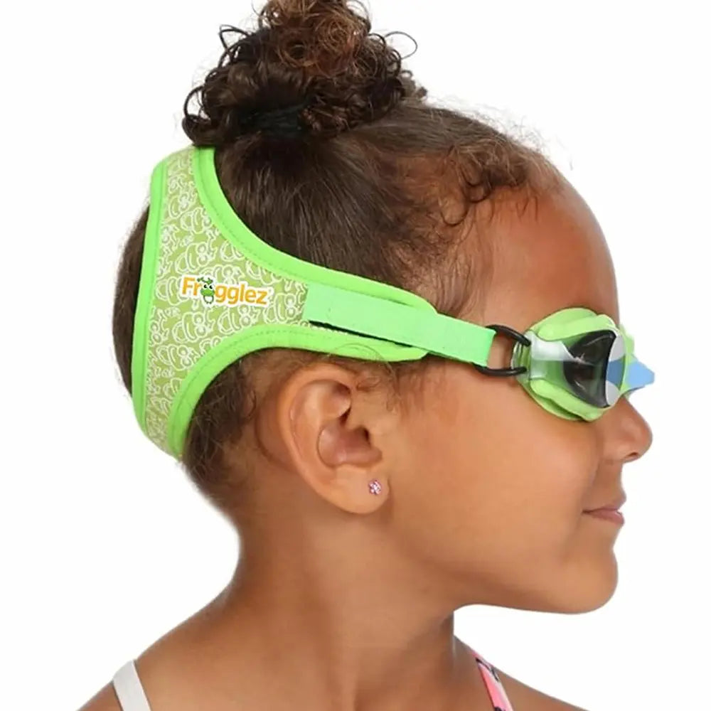 Child wearing green Frogglez swim goggles with a white background
