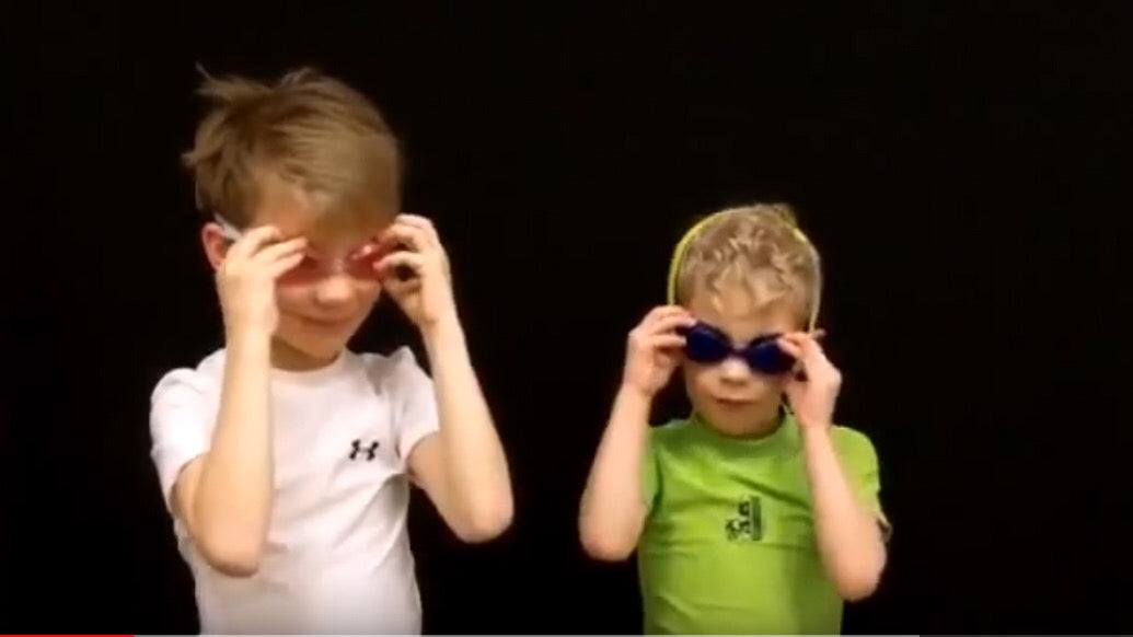 Two boys trying swim goggles in swimsuits