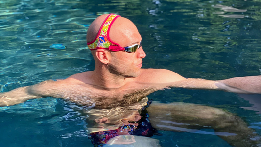 Austin Surhoff in the swimming pool looking to his left to display the Pink Frogglez Swim Goggles that he is wearing.