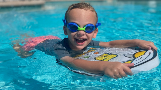 boy at swim lessons wearing Frogglez Goggles blue frogz lenses in pool 